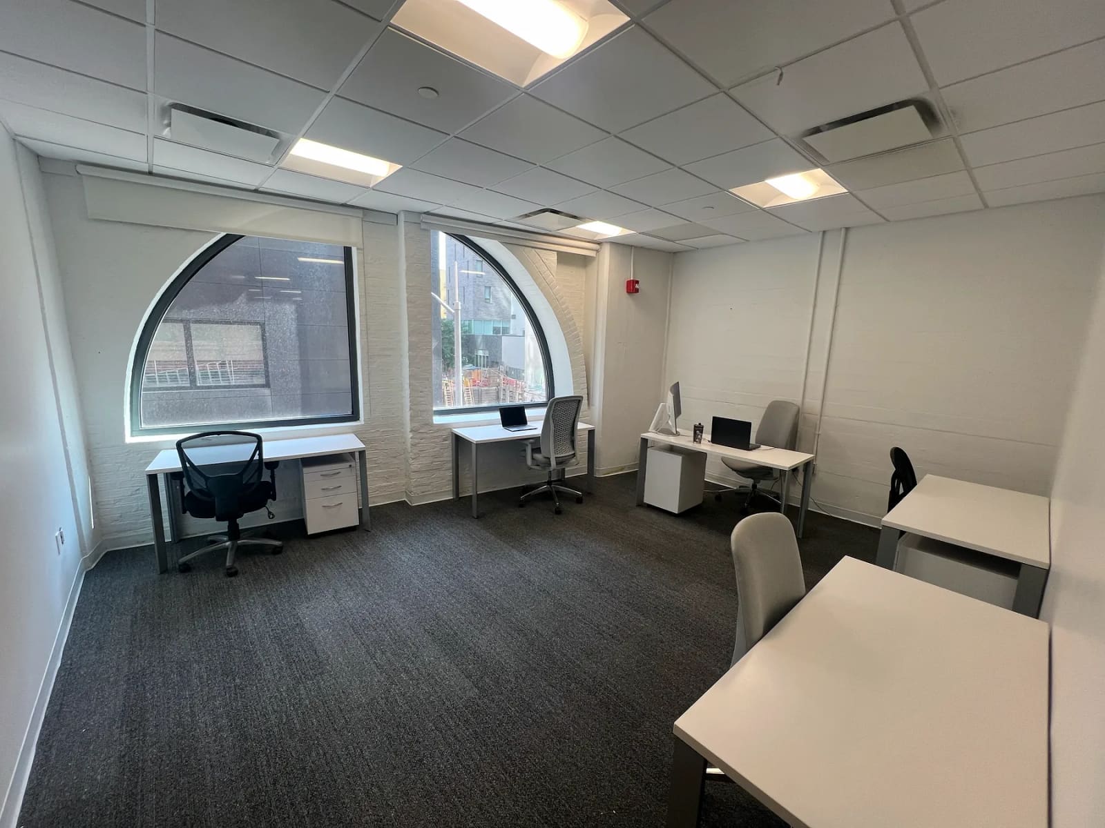Desks and arched windows inside the Clarkes.Team office at 41 Flatbush Avenue in Brooklyn.