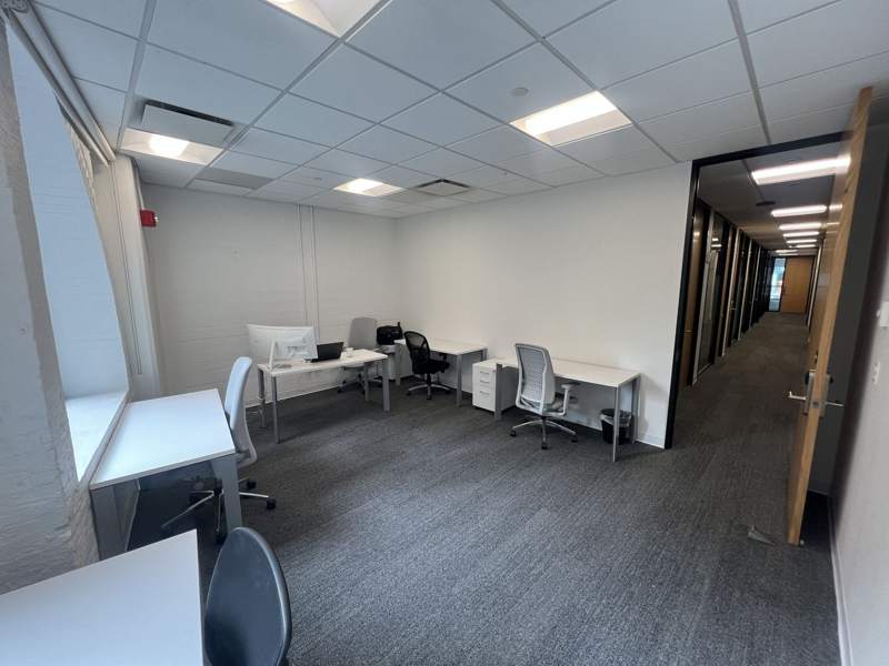 Desks in the Clarkes.Team office with the second-floor hallway beyond